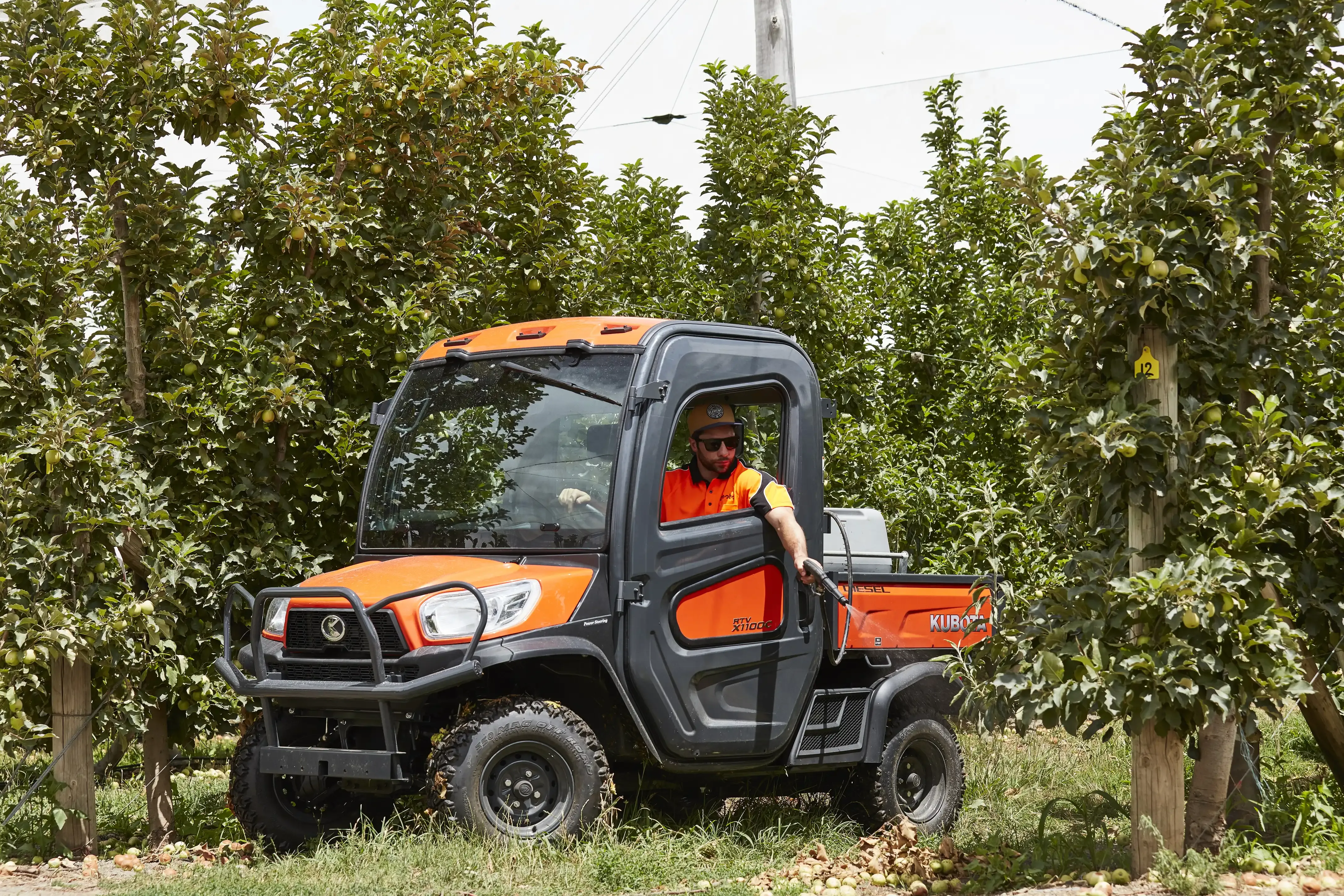 A man is driving a utility vehicle through a forest. — Ken Mills Machinery in Kingaroy, QLD