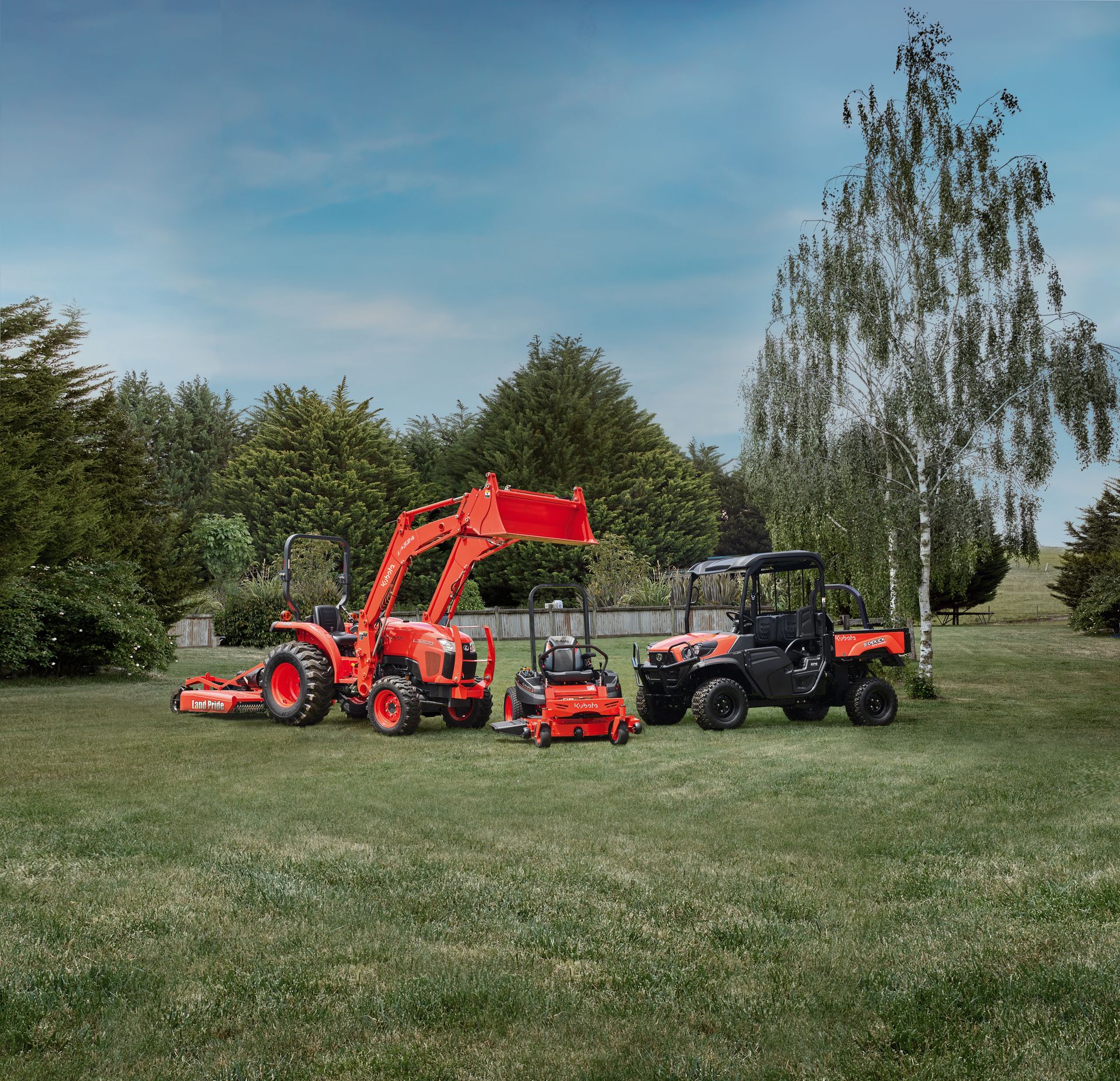 A Man is Riding a Lawn Mower on a Lush Green Lawn — Ken Mills Machinery in Kingaroy, QLD