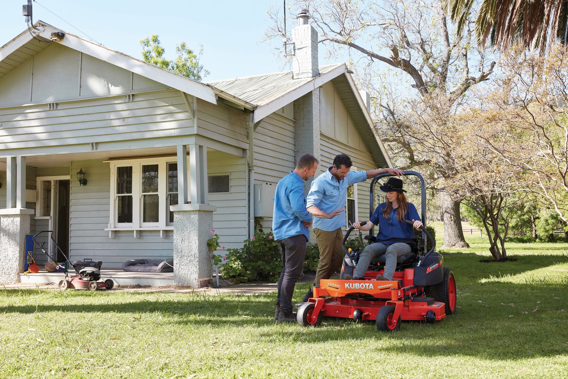 A woman is riding a lawn mower on a lush green field. — Ken Mills Machinery in Kingaroy, QLD