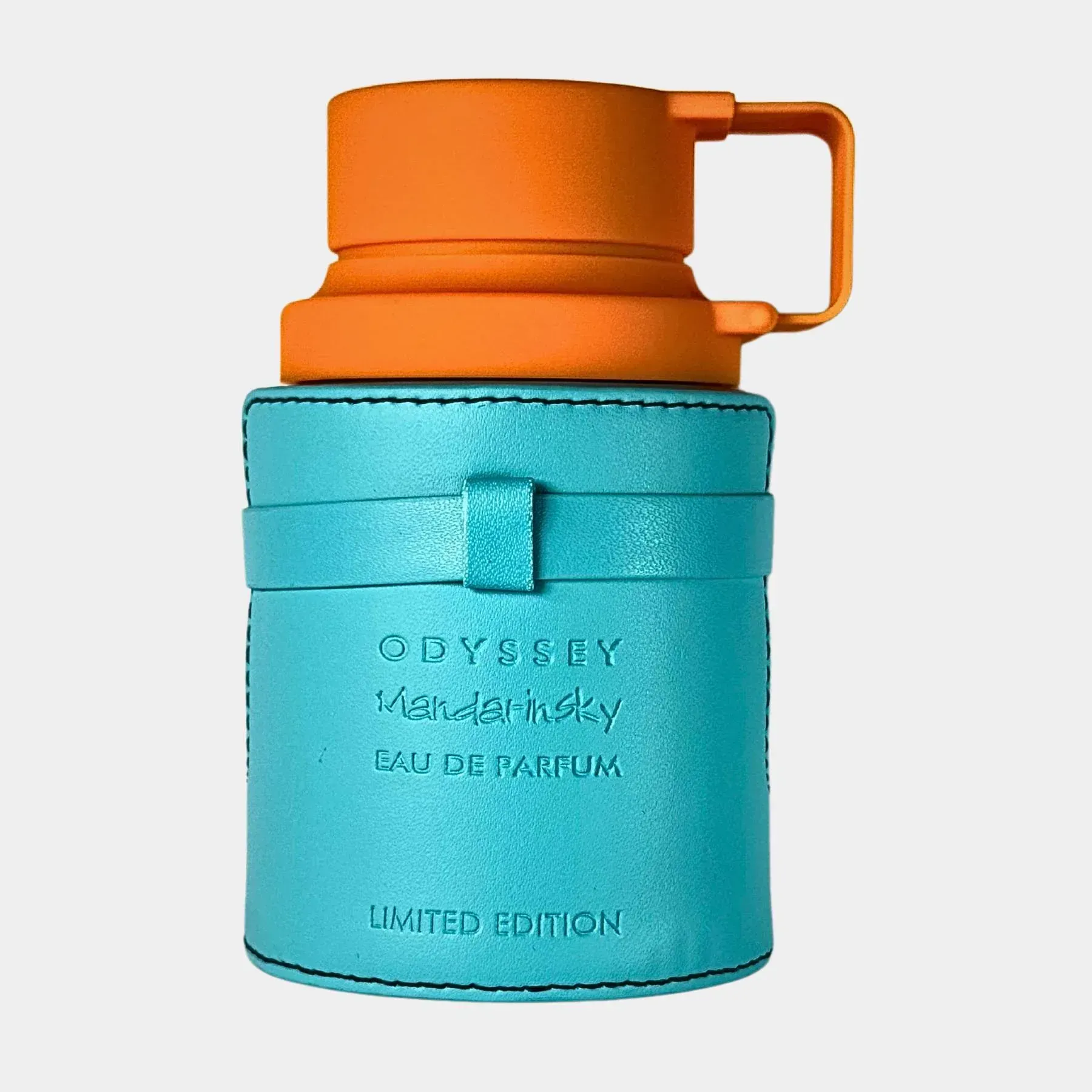 Una caja naranja del perfume “Odyssey Mandarin Sky” sobre un fondo color melocotón jaspeado.