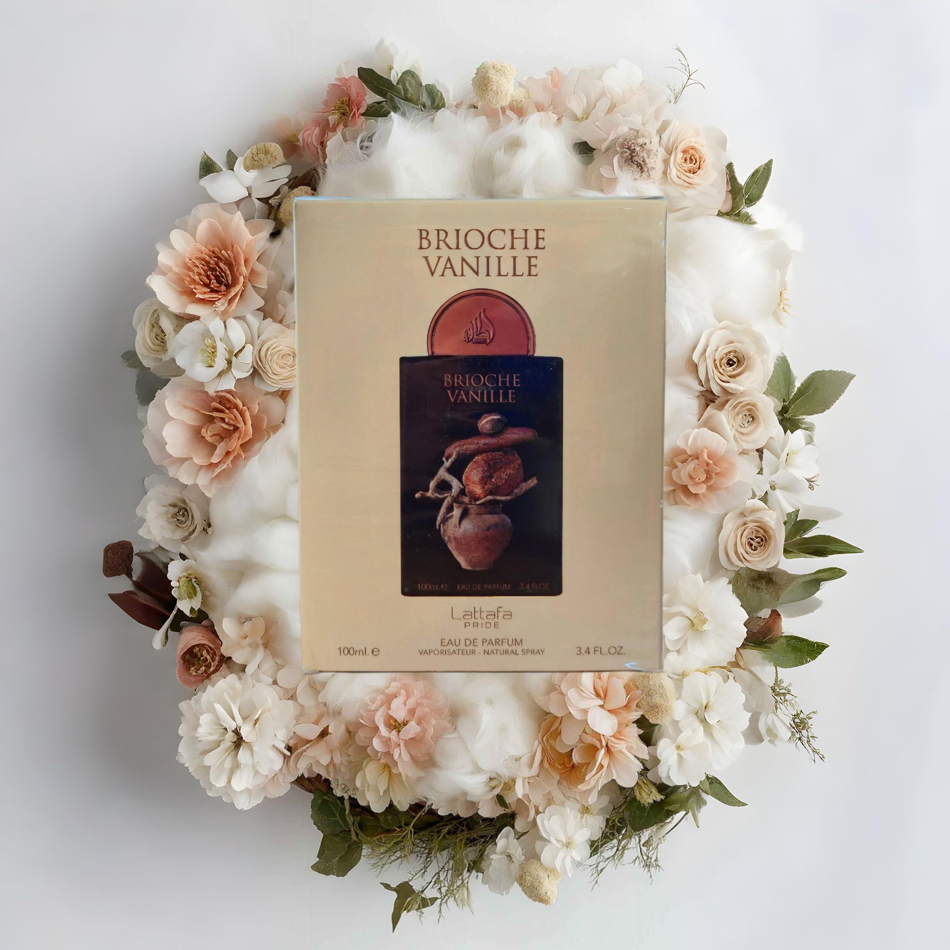 Caja de perfume “Brioche Vanille”, centrada en una corona de flores y algodón sobre un fondo blanco.