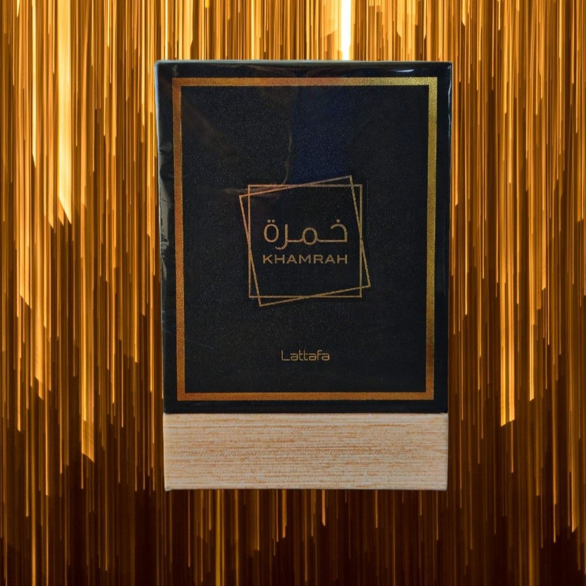 Caja de perfume Khamrah con detalles dorados sobre un fondo dorado difuminado.