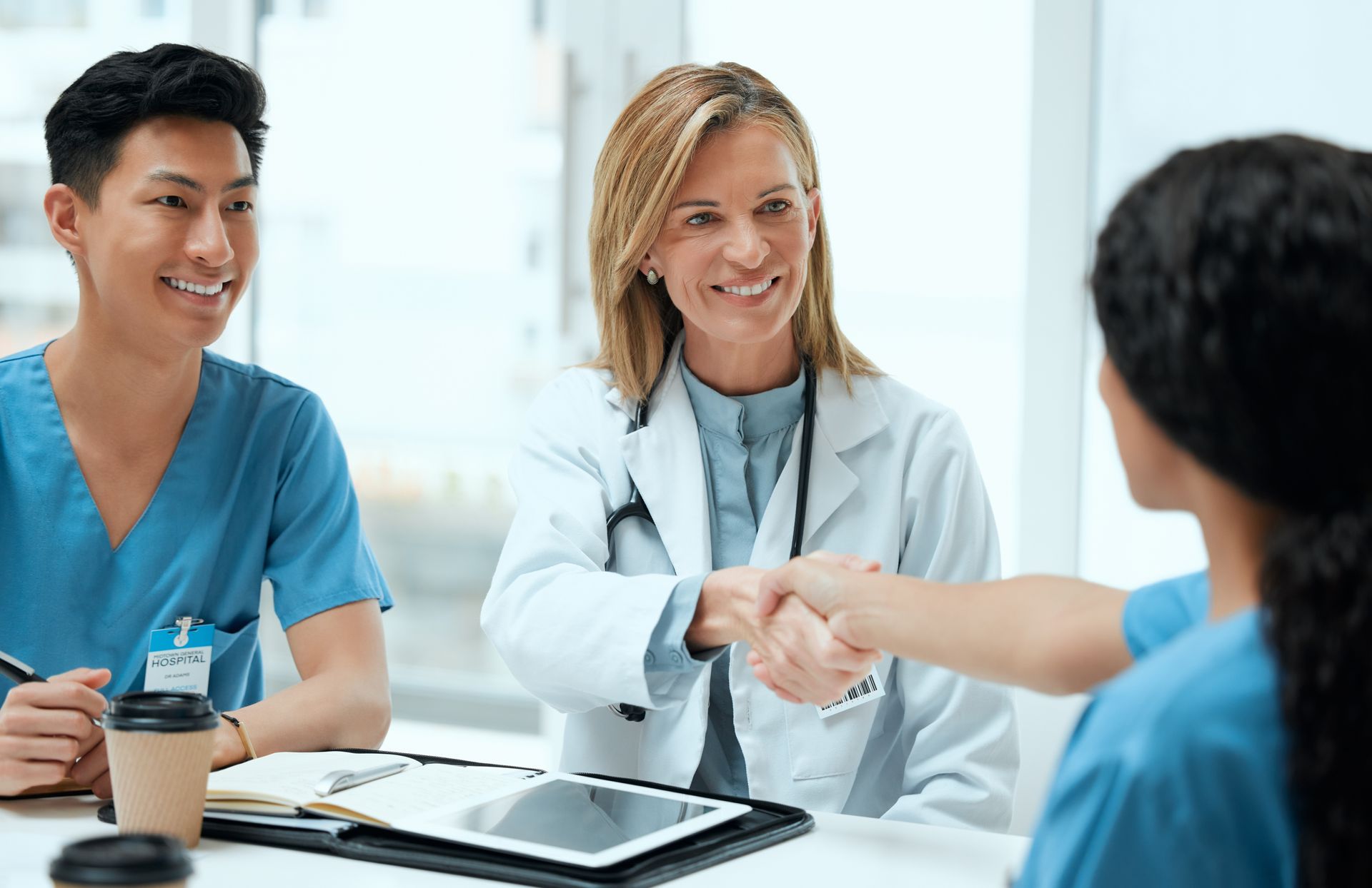 Healthcare staff shaking hands during a meeting in a bright clinic office