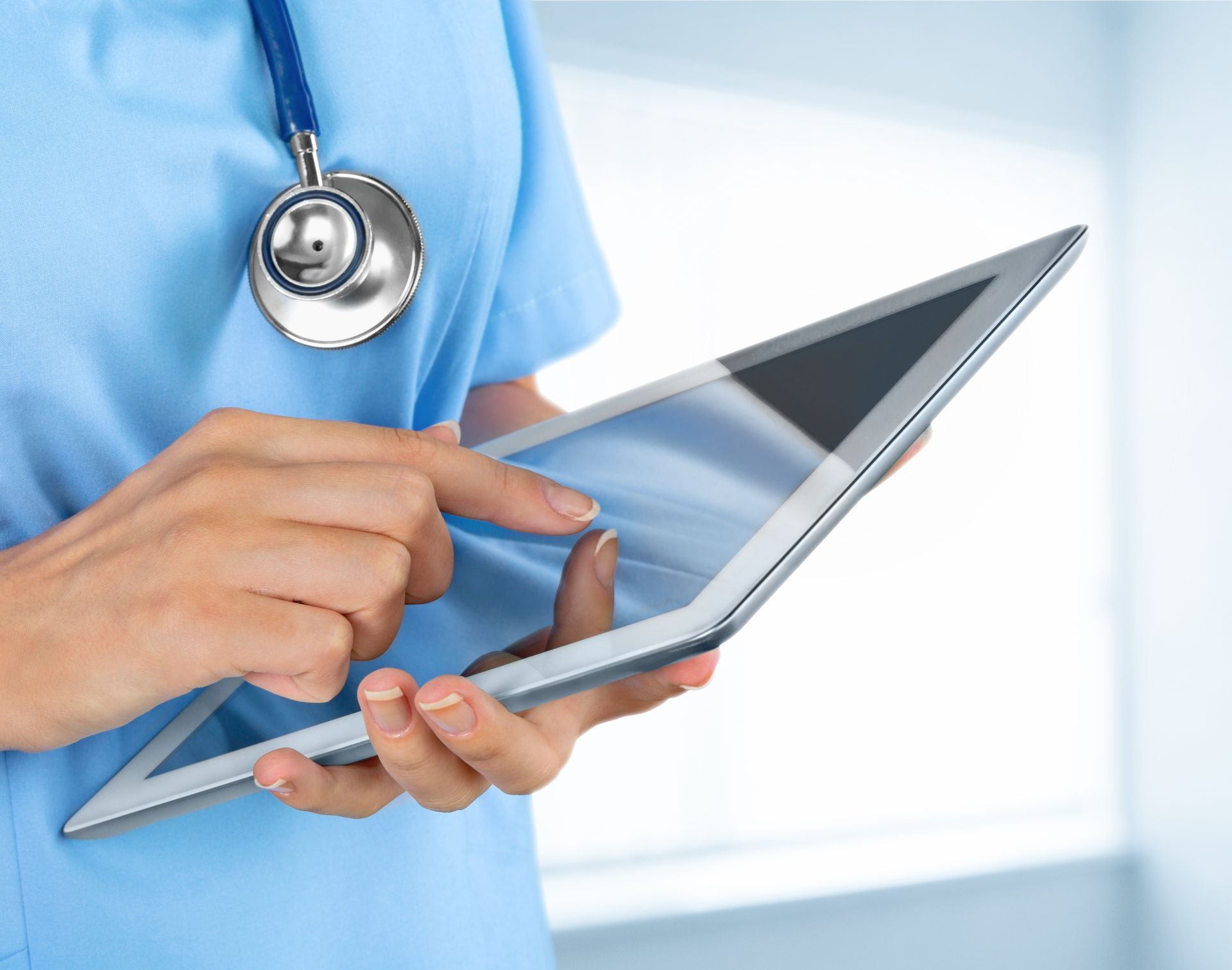 Doctor using a tablet with a stethoscope around the neck