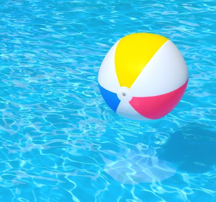 A Colourful Beach Ball Is Floating In A Swimming Pool — All Bright Pool Care In Laurieton, NSW