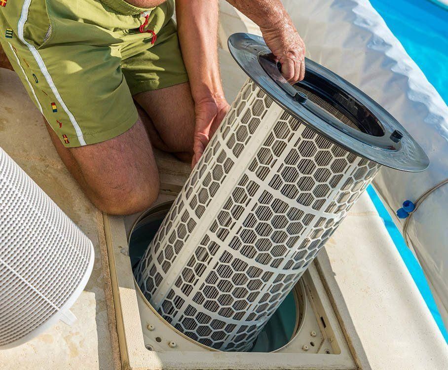 A Man Is Cleaning A Pool Filter — All Bright Pool Care In Laurieton, NSW