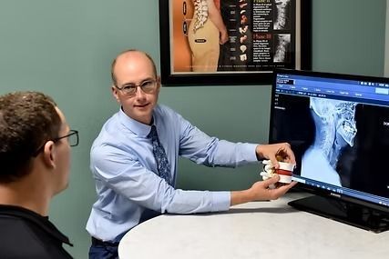 patient looking at Dr. John explain x-rays
