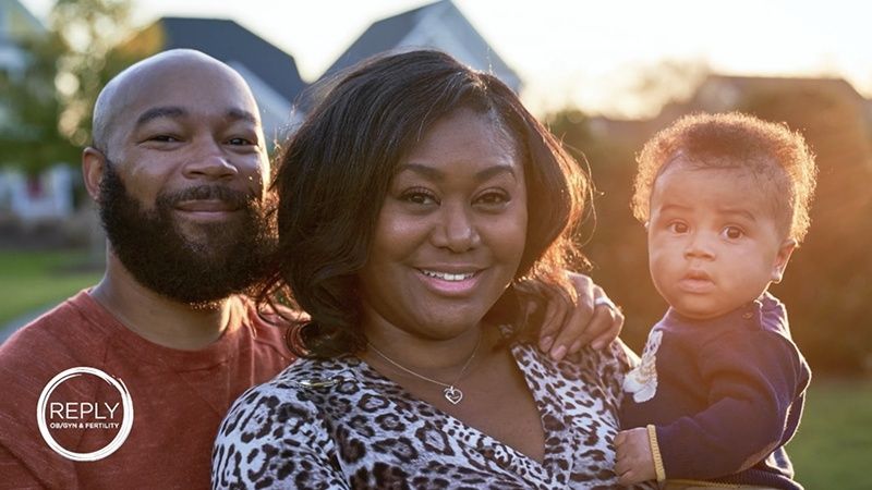 A man and a woman are posing for a picture with a baby.