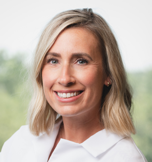 A woman in a white shirt is smiling for the camera.