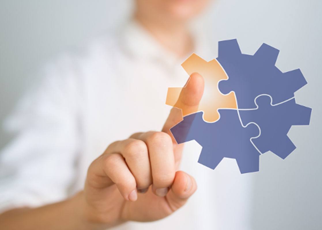 A person is holding a piece of puzzle that looks like a gear
