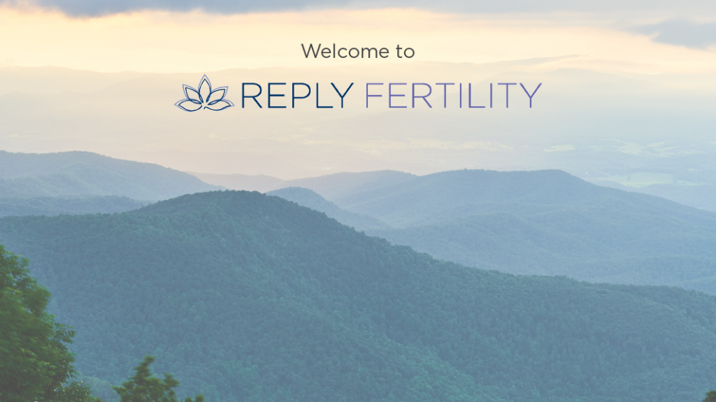 A man and woman are sitting on a porch holding a baby.