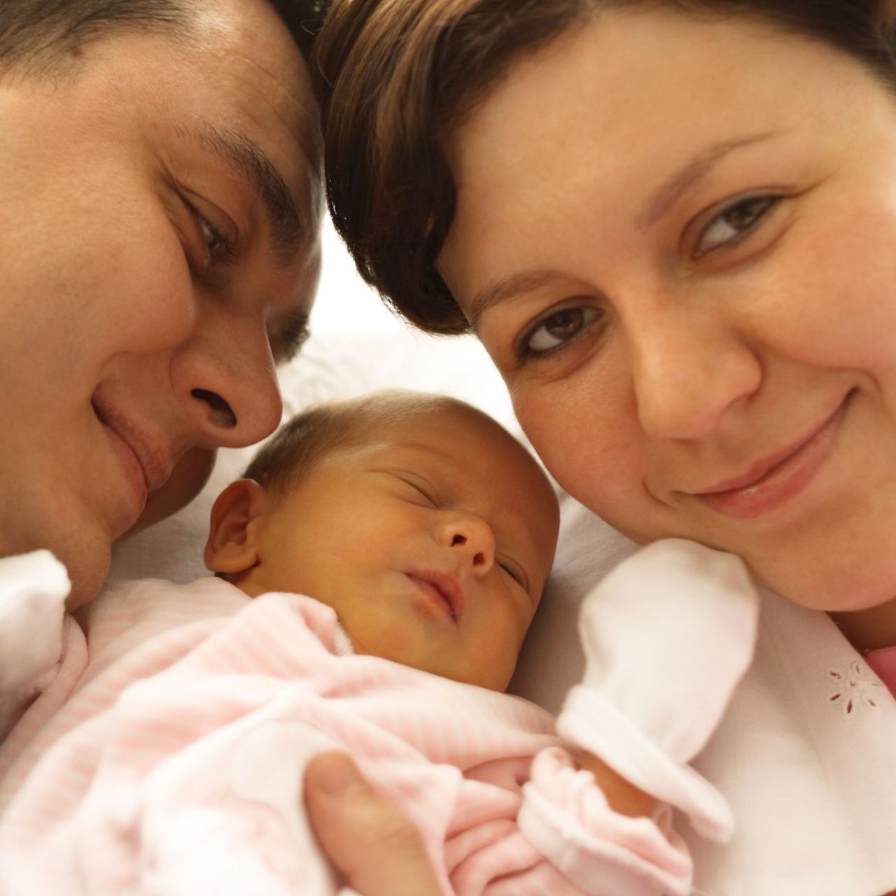 A man and woman are holding a baby in their arms