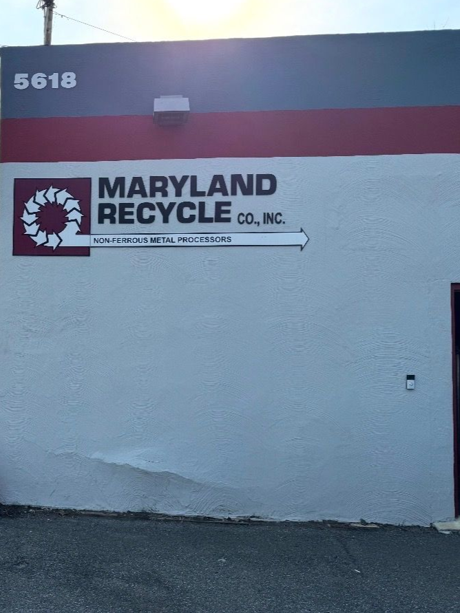 Exterior view of a Maryland Recycle Co., Inc. building with red, gray, and white paint and the number 5618 at the top.