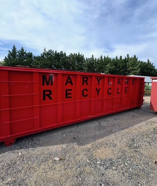 A long, bright red dumpster labeled
