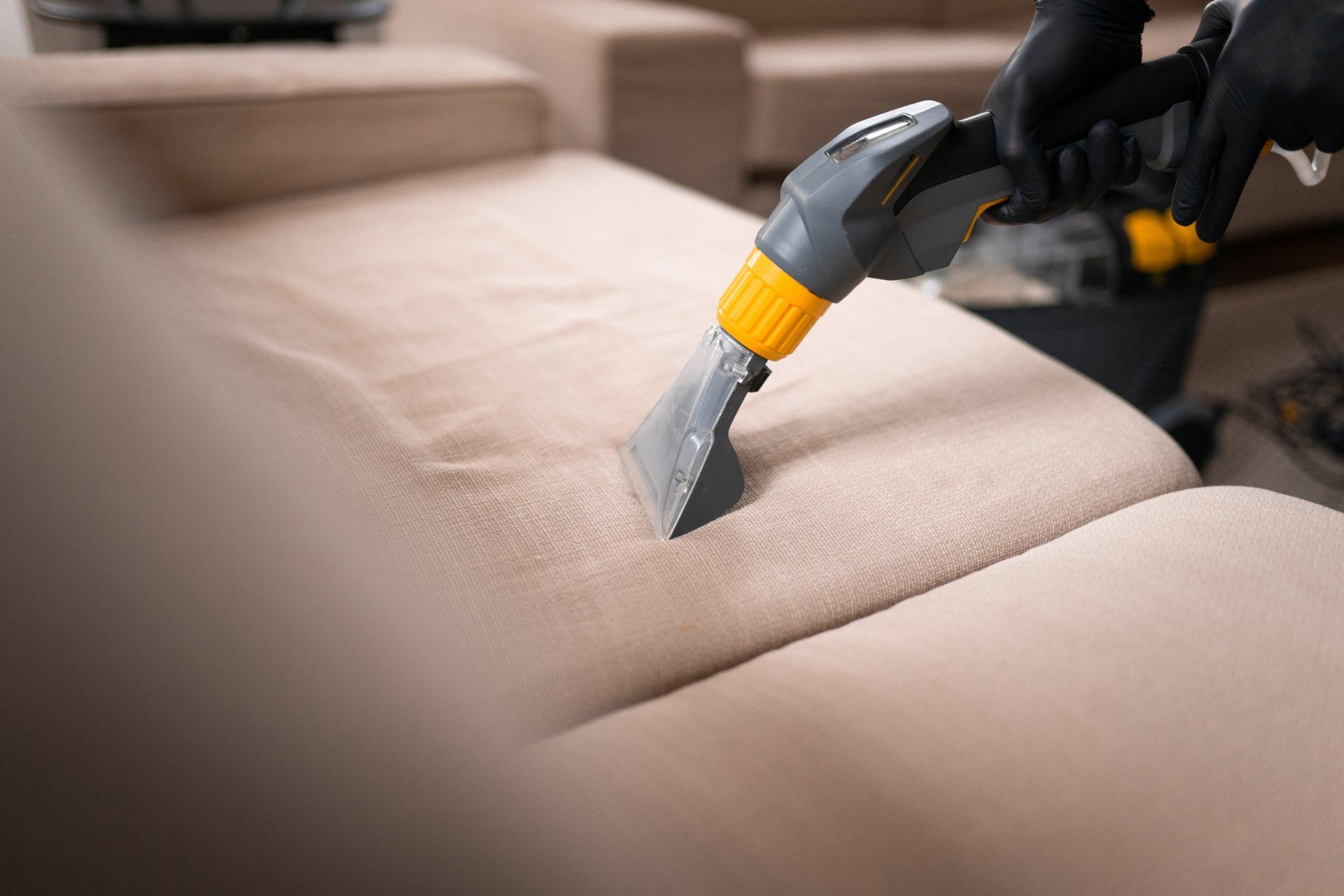 Man Vacuuming a Sofa — Waynesburg, PA — Sluggers Carpet & Upholstery Cleaning