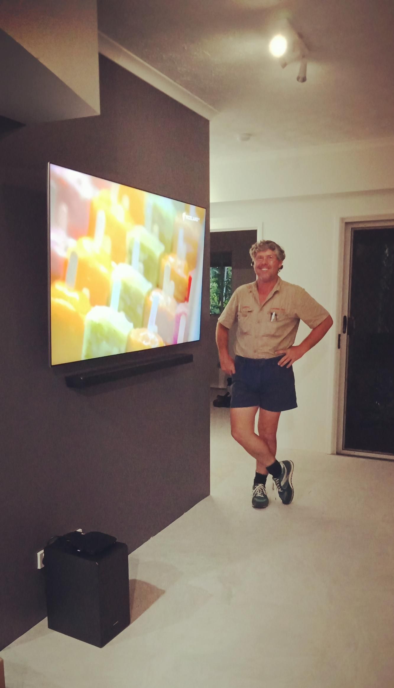 A Man Is Standing In Front Of A Flat Screen Tv — Laurence Capocchi Antenna Guy In Trinity Beach, QLD