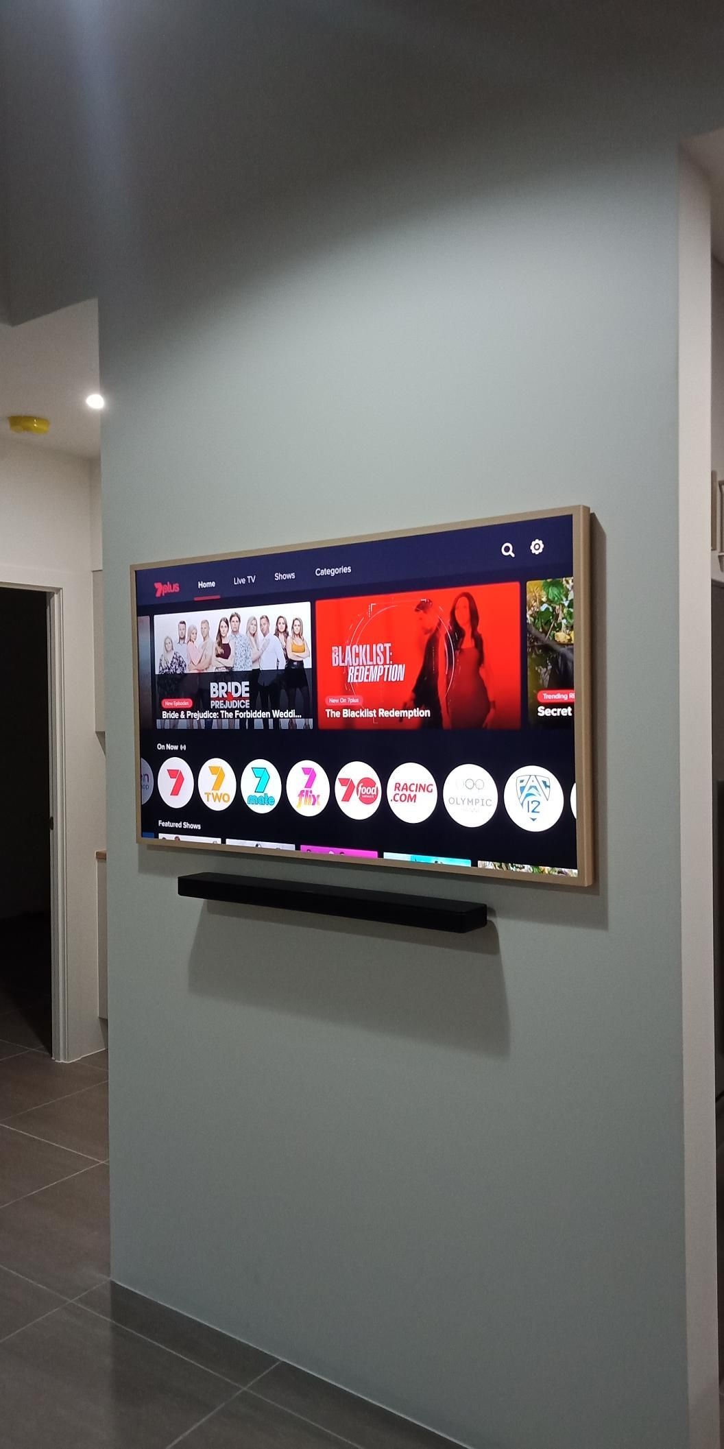 A Flat Screen Tv Is Hanging On A Wall In A Living Room — Laurence Capocchi Antenna Guy In Trinity Beach, QLD