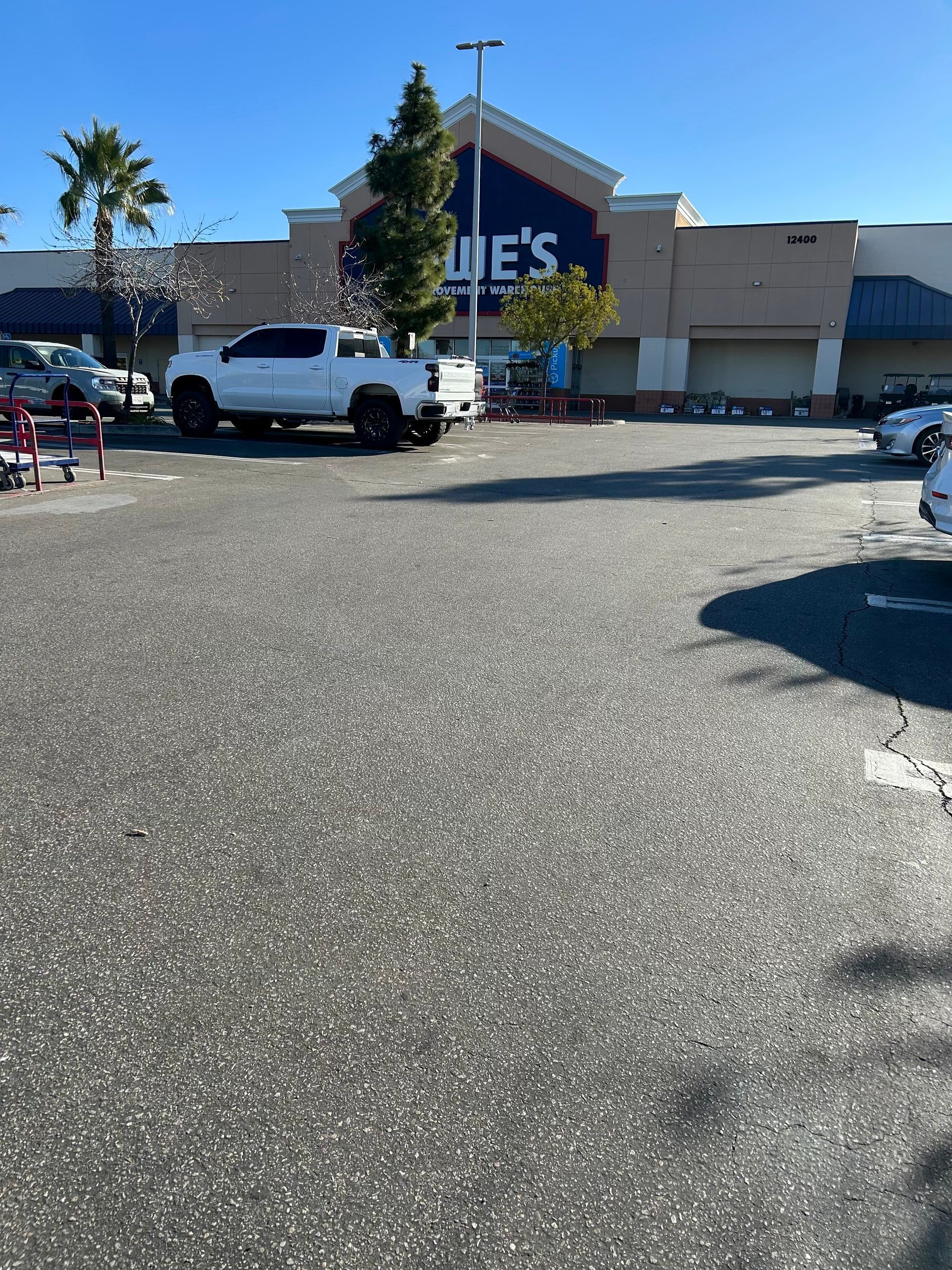 A white truck is parked in front of a store called jules