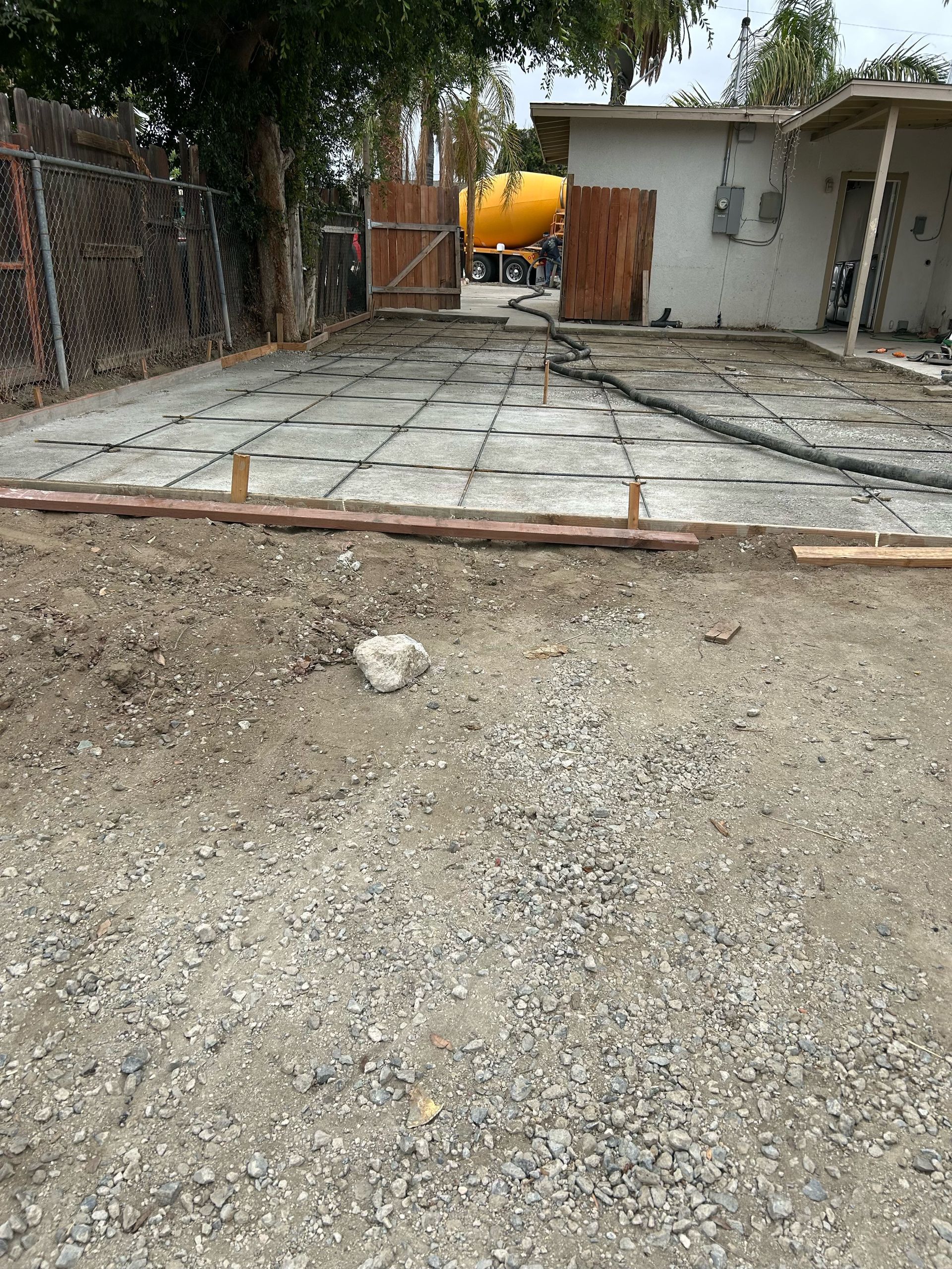 A concrete driveway is being built in front of a house.