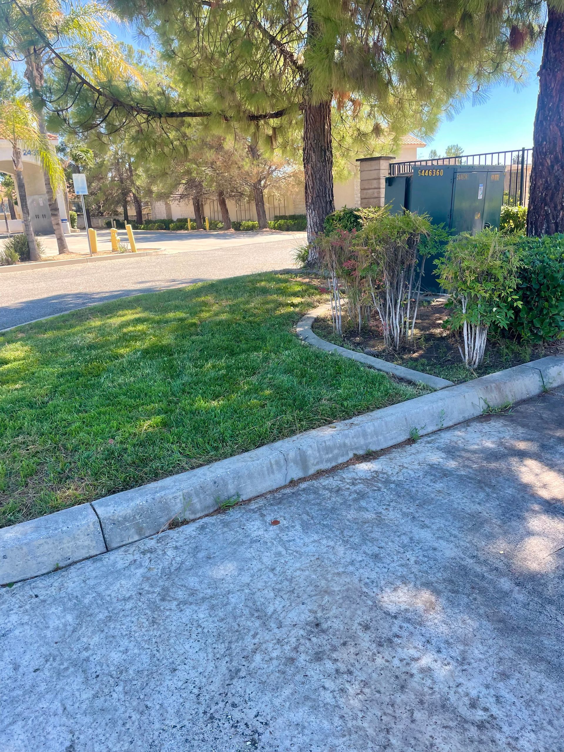 a concrete curb with a fence and a green box that says ' ambulance ' on it