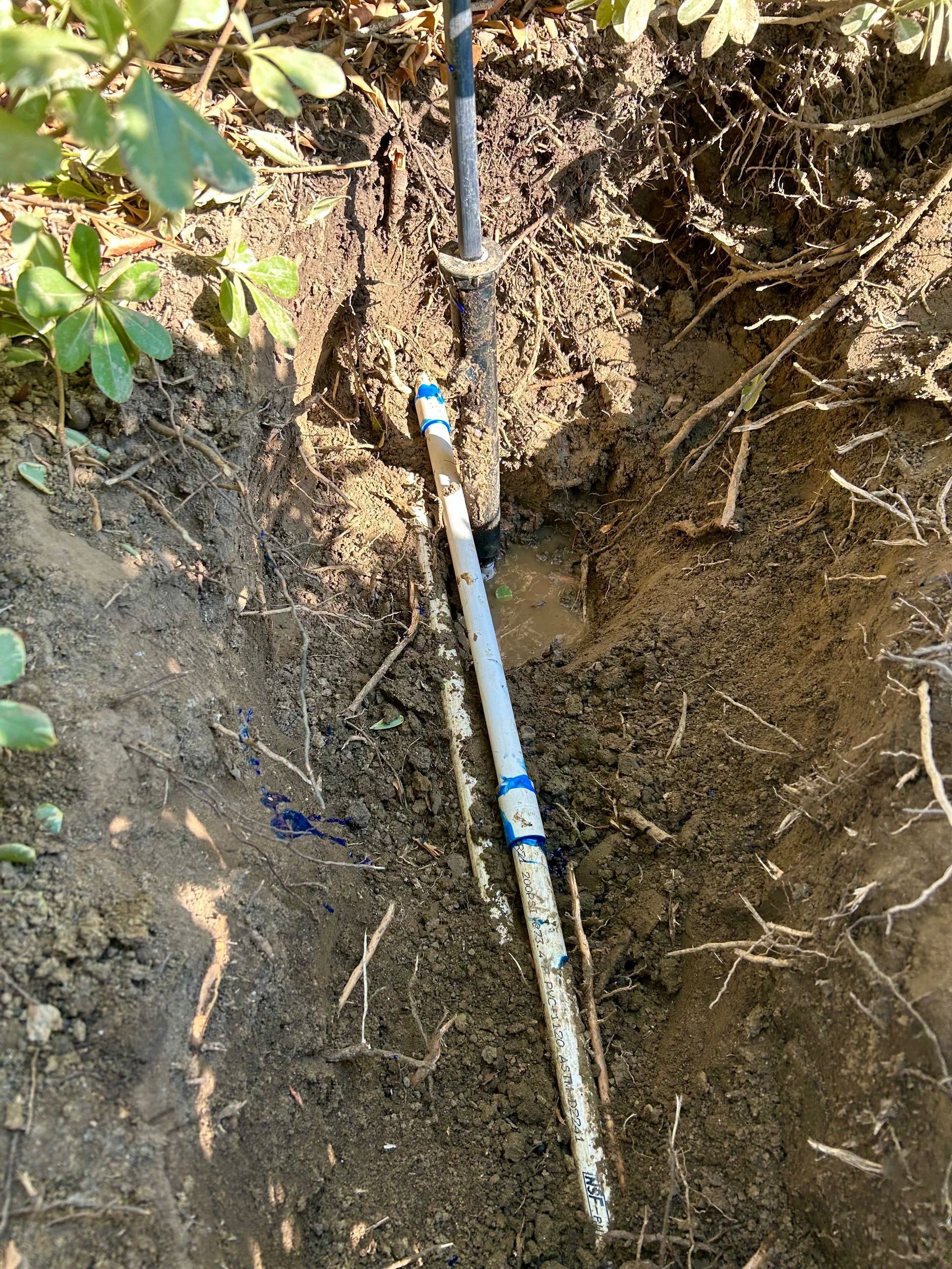 A pipe is sticking out of the ground in the dirt.