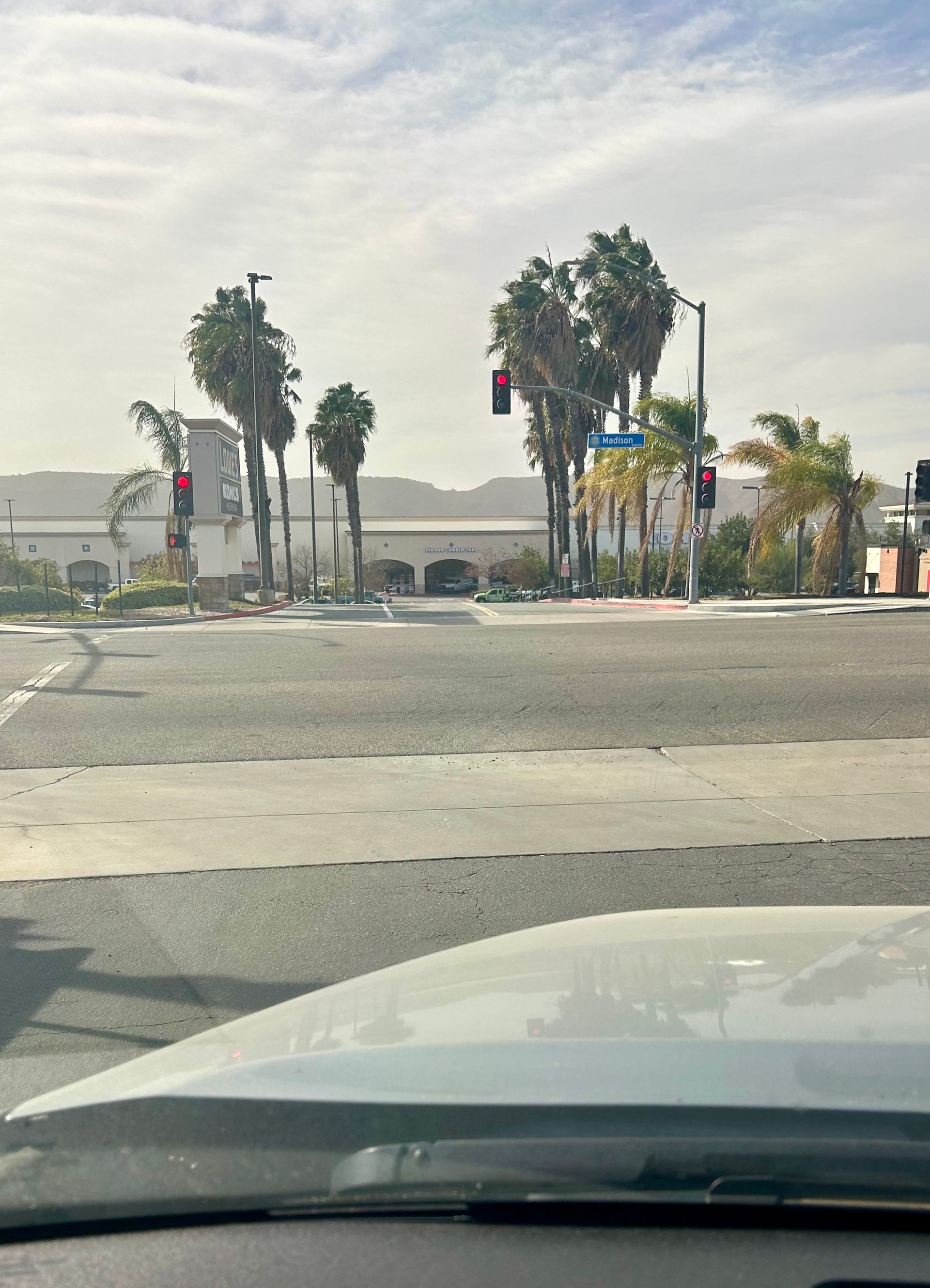 A car is driving down a street with palm trees in the background