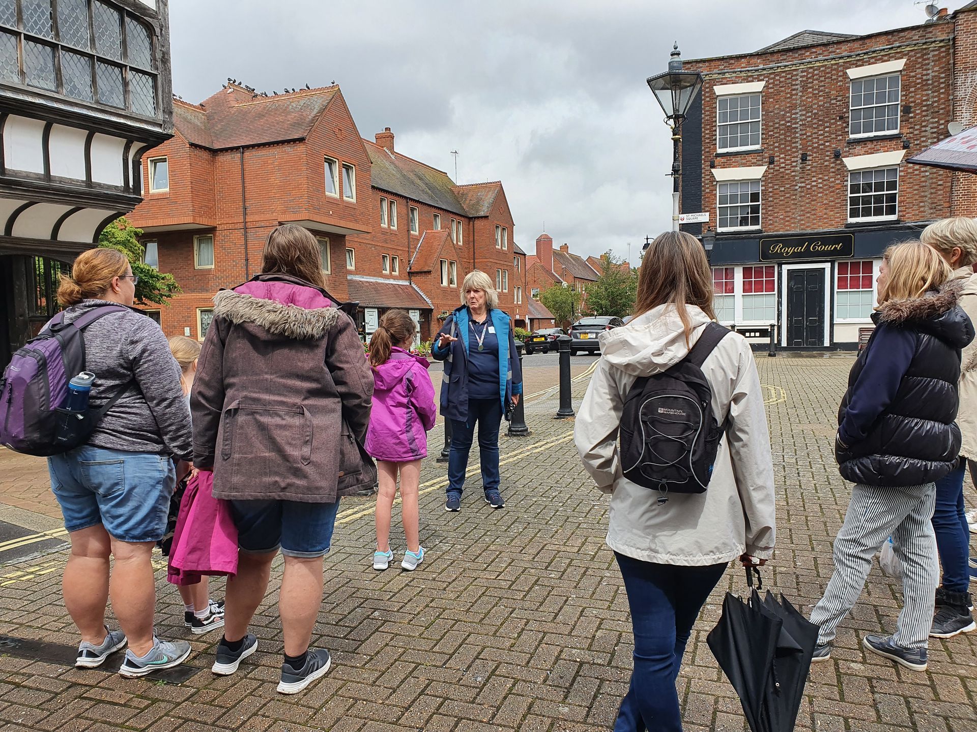 A group of people are walking down a cobblestone street.