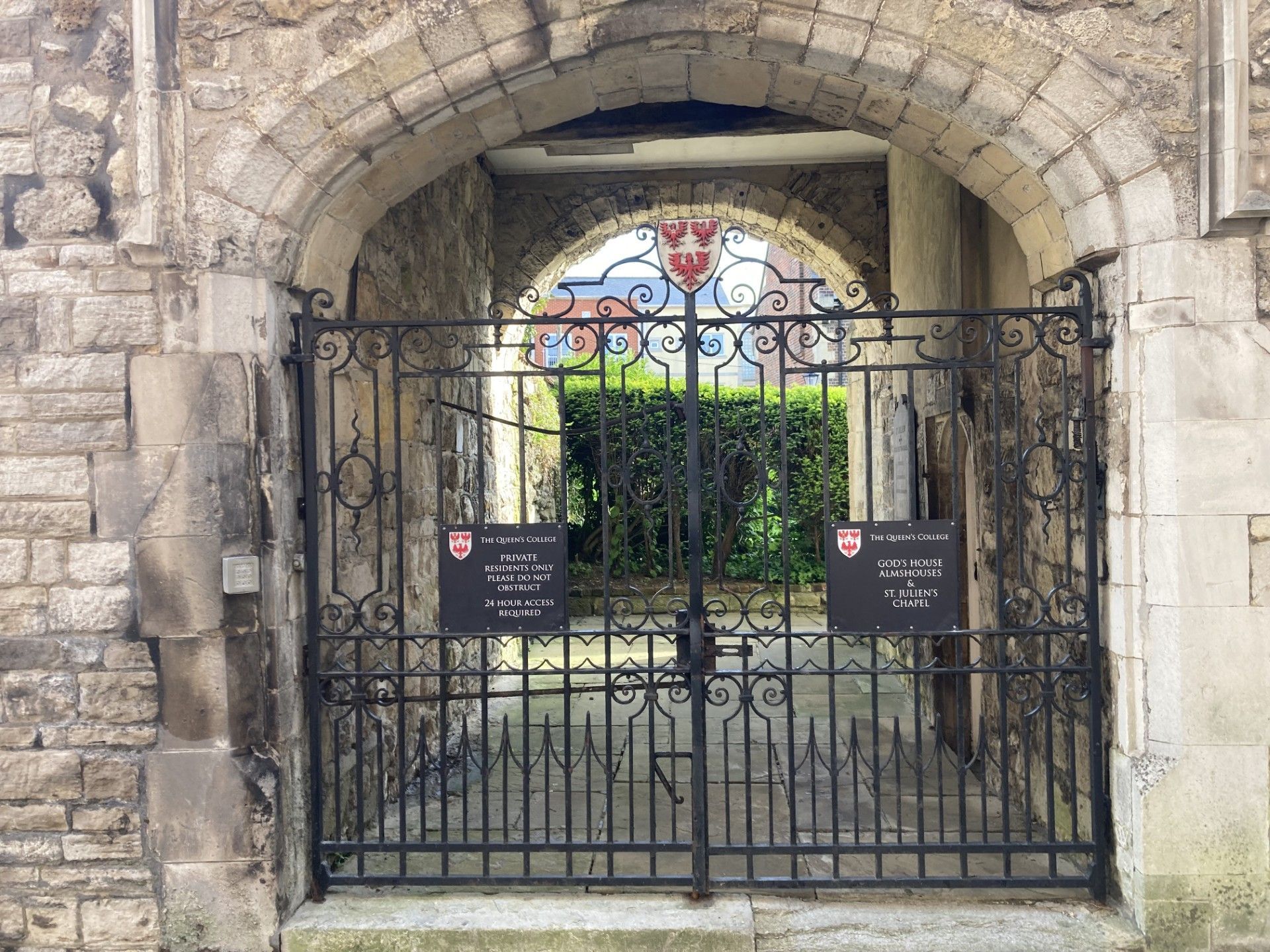 A brick building with a wrought iron gate in front of it