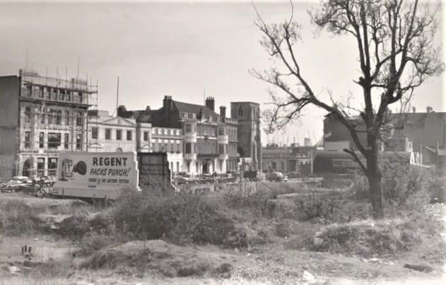 A black and white photo of a city street with a truck that says regent on it.