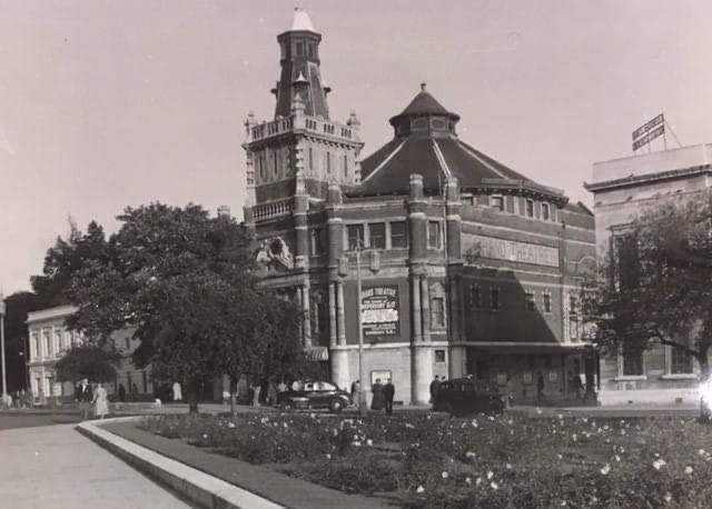 A black and white photo of a large building with a clock tower