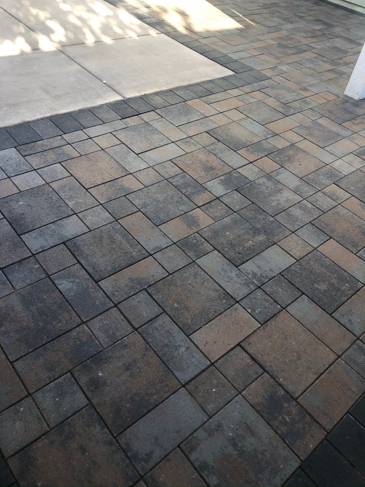 A close up of a brick pavement with a concrete border.