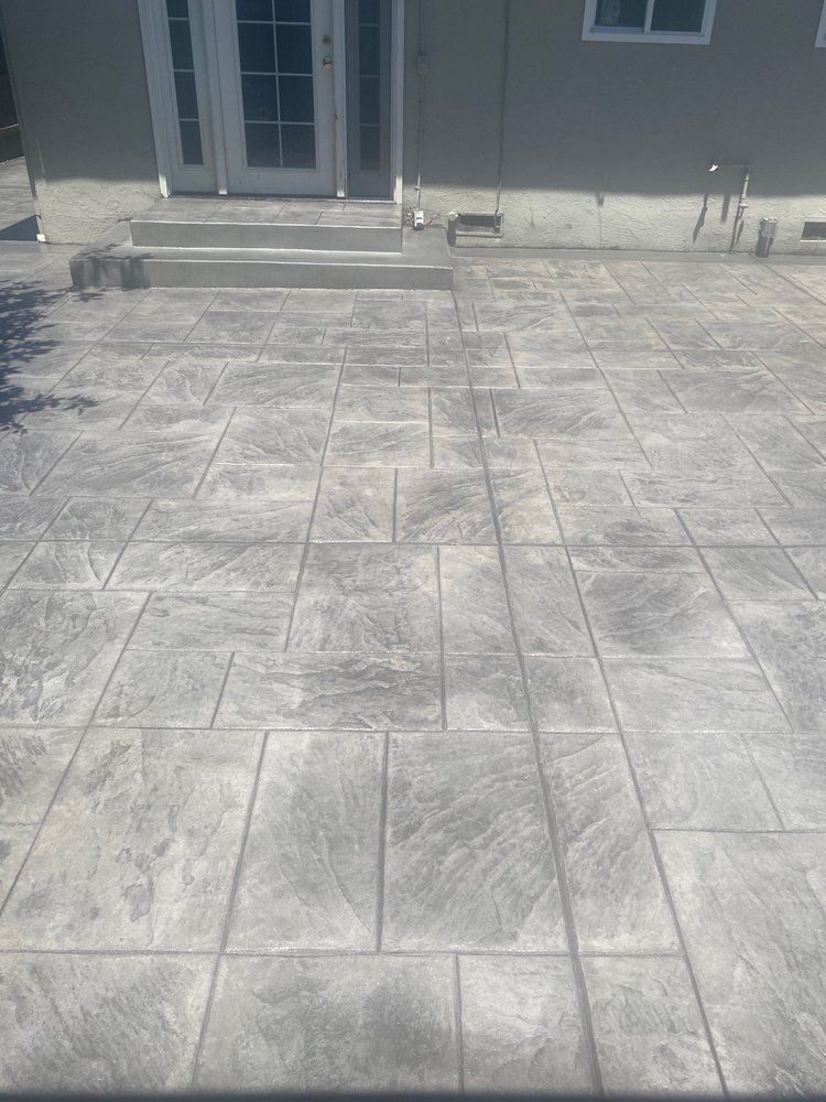 A concrete patio with steps leading up to a house.