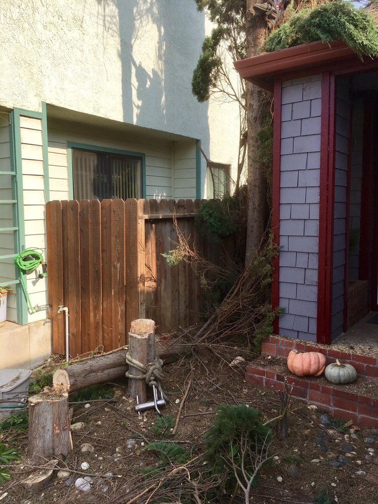 A house with a wooden fence and pumpkins in front of it