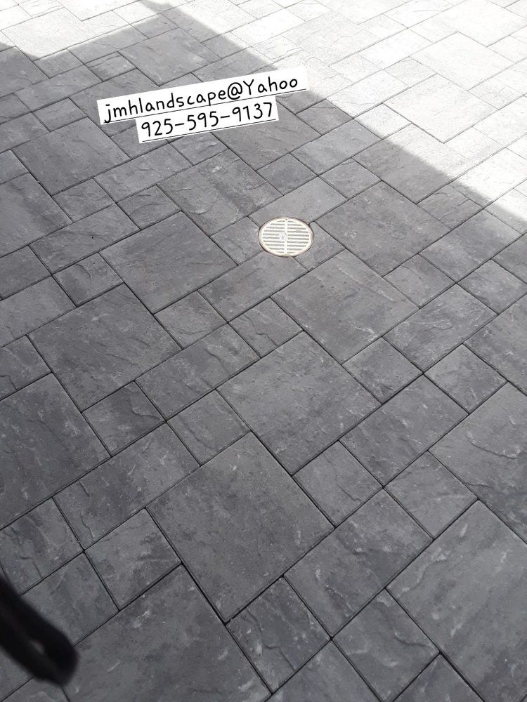 A black and white photo of a brick floor with a phone number on it.