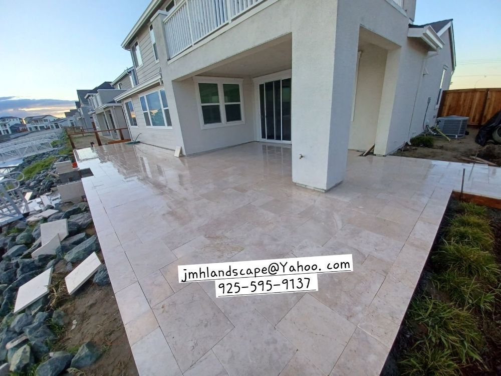 A large white house with a patio in front of it.