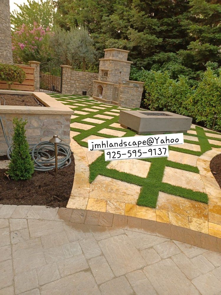 A patio with a fire pit and a sign that says jim landscape @ yahoo