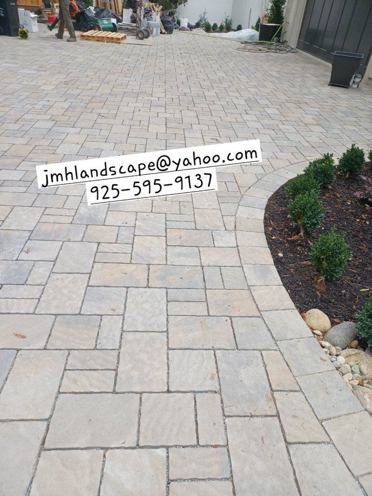 A brick driveway with a phone number on it