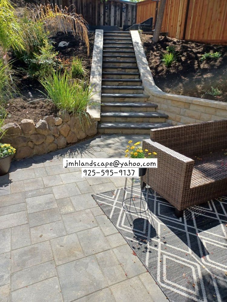 There are stairs leading up to a patio with a chair and table.
