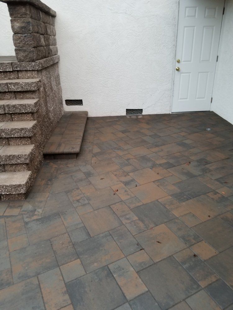 A patio with stairs and a door in the background