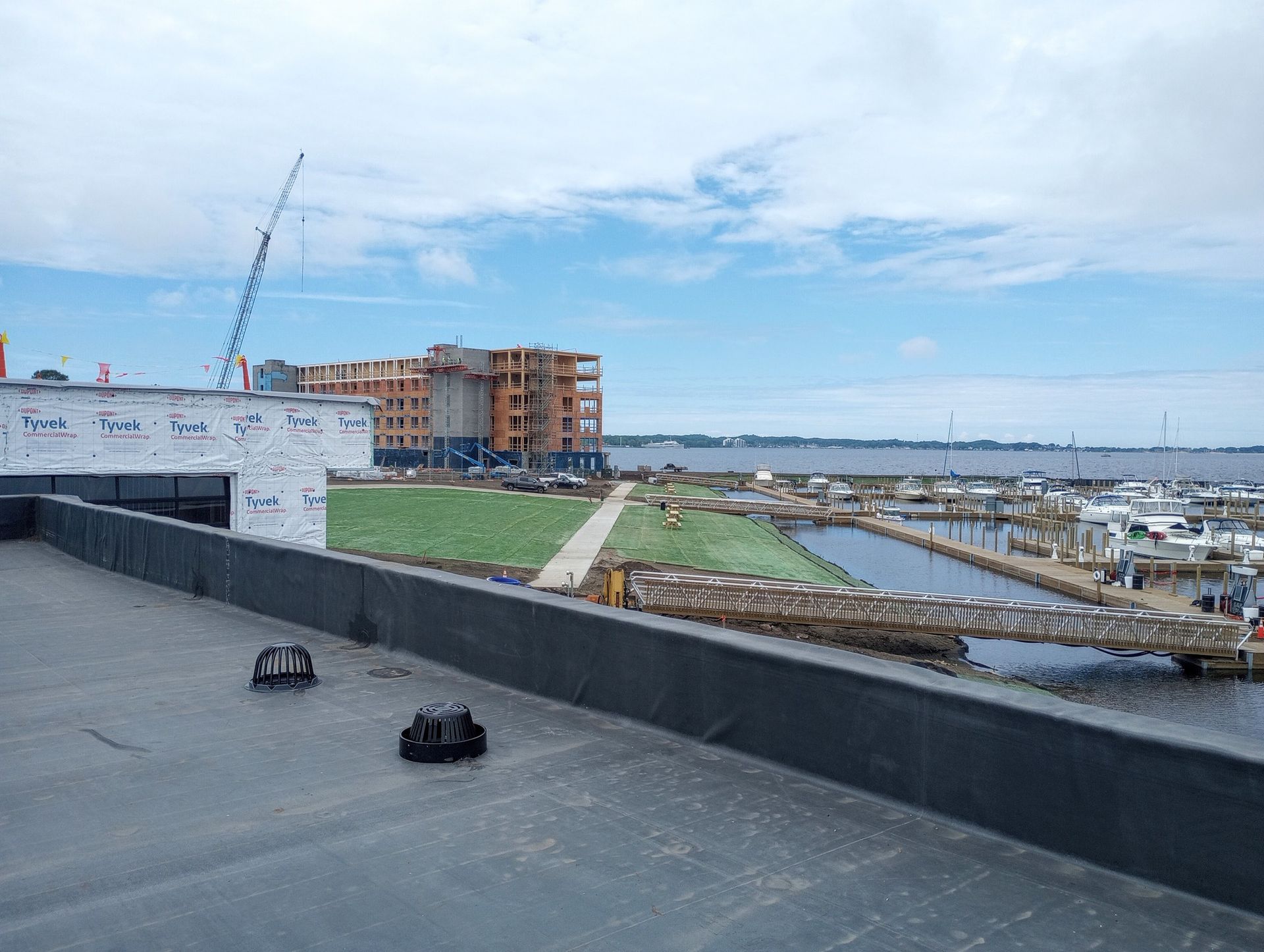 Rooftop view of a marina, construction building, and blue sky over water