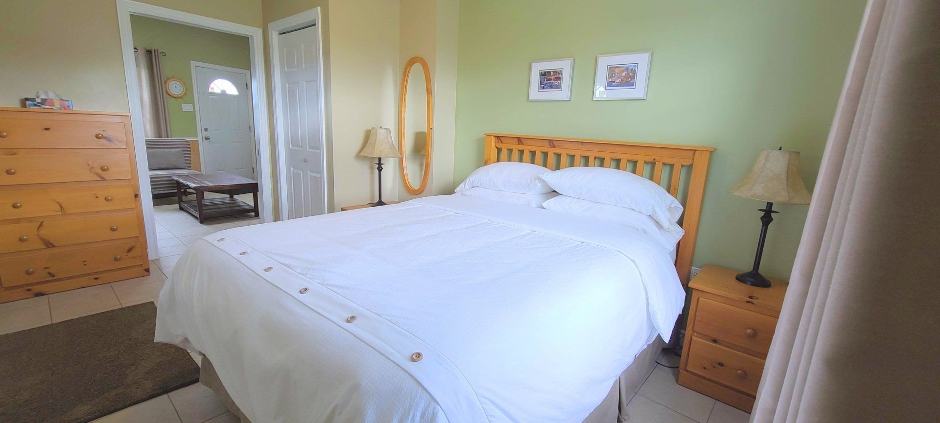 Bright bedroom, with white queen bed and nightstands.