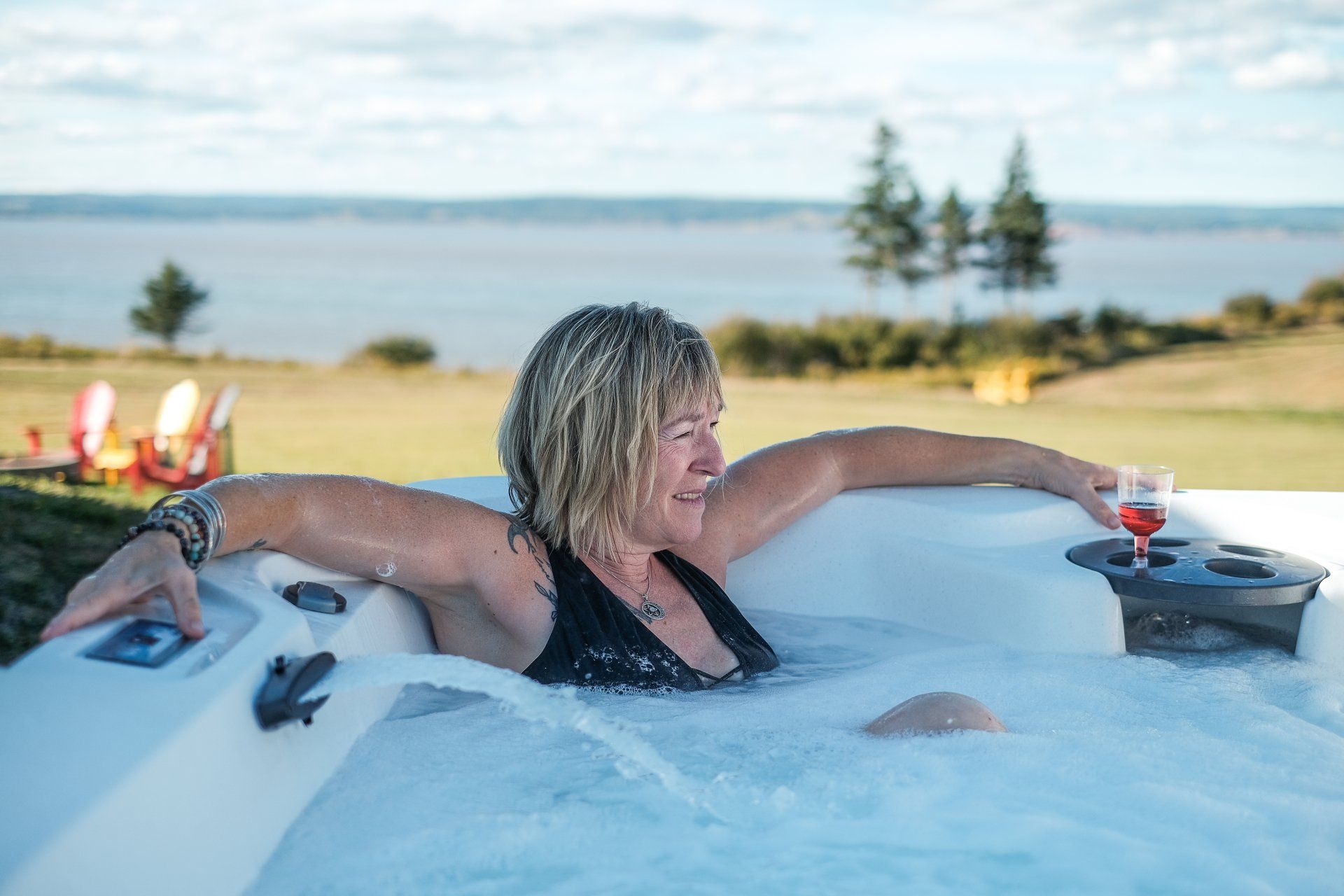person in a hot tub with the bay of fundy in the background