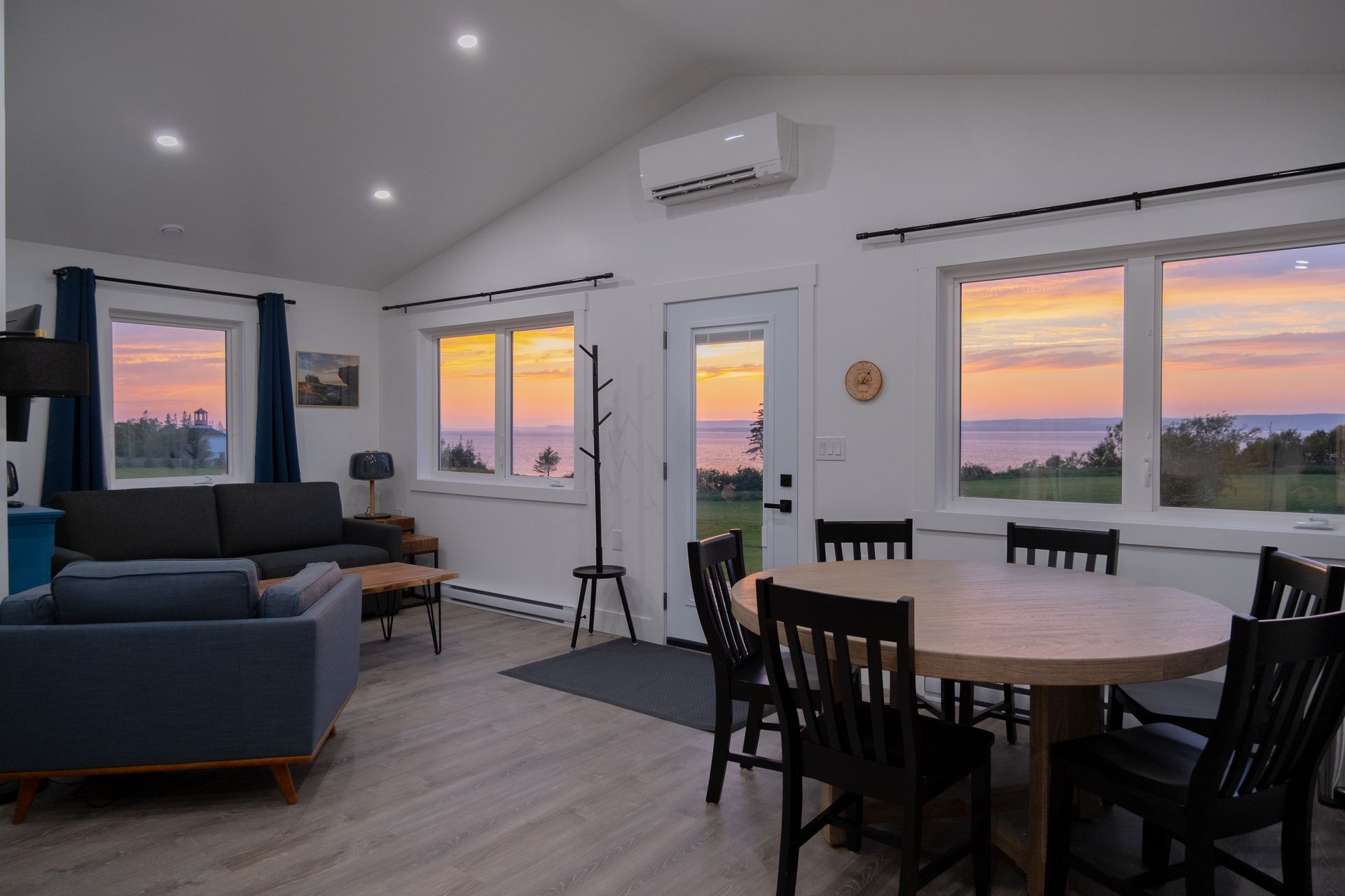 large open concept living area with large picture windows showcasing a beautiful moon mist sunset over the bay of fundy.