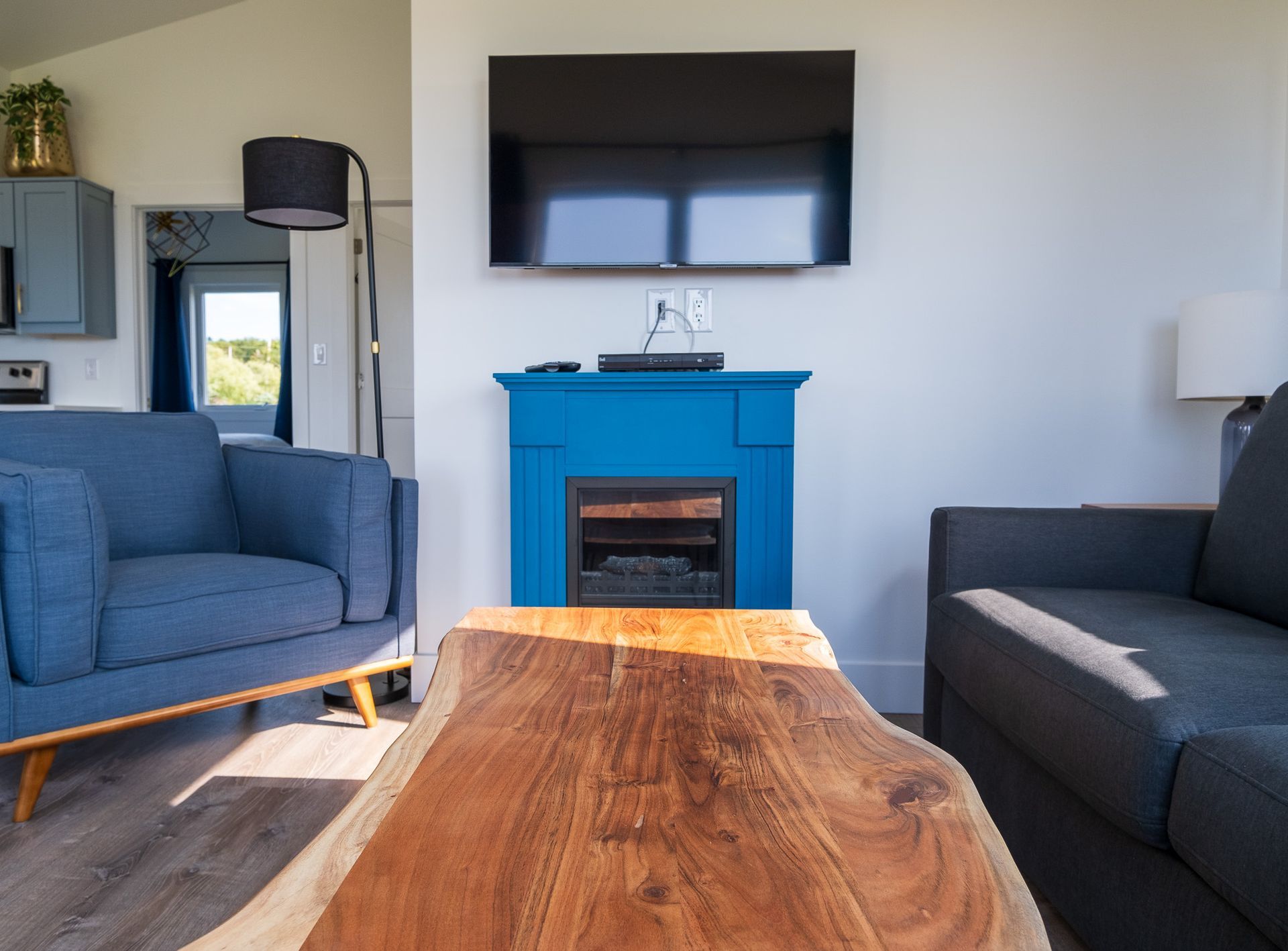 living area with fireplace, tv, arm chair, and couch