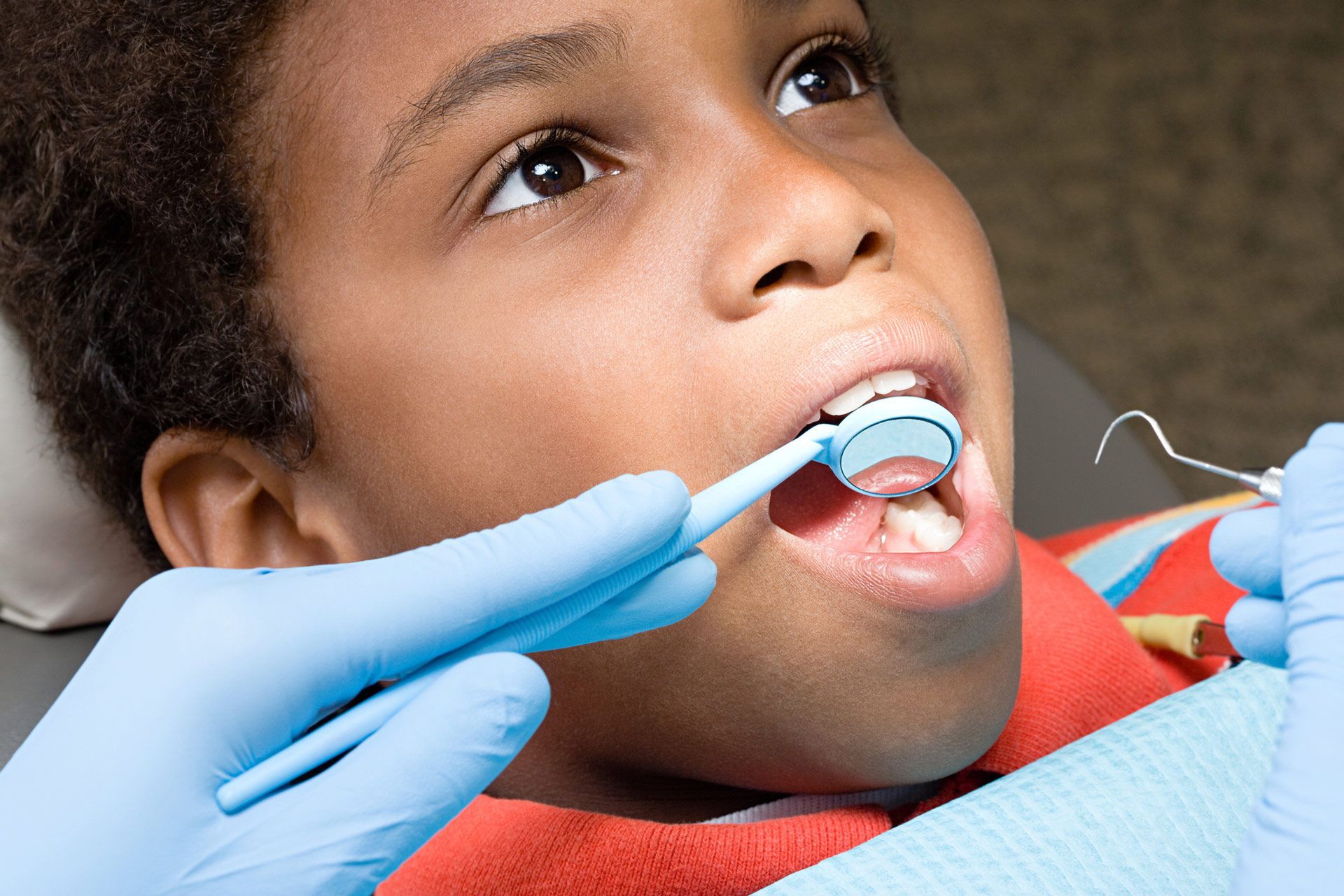 Close-up of patient being checked to get white fillings by pediatric dentist