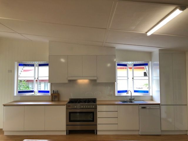 Kitchen With White Cabinetry, Light Wood Countertops, a Stainless Steel Stove — Craftsmen Kitchens In Monkland, QLD