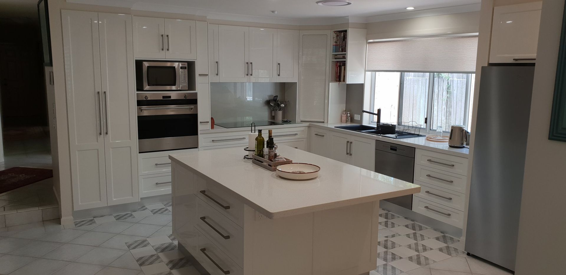 Kitchen With a Center Island, Stainless Steel Appliances, and Patterned Floor Tiles — Craftsmen Kitchens In Monkland, QLD