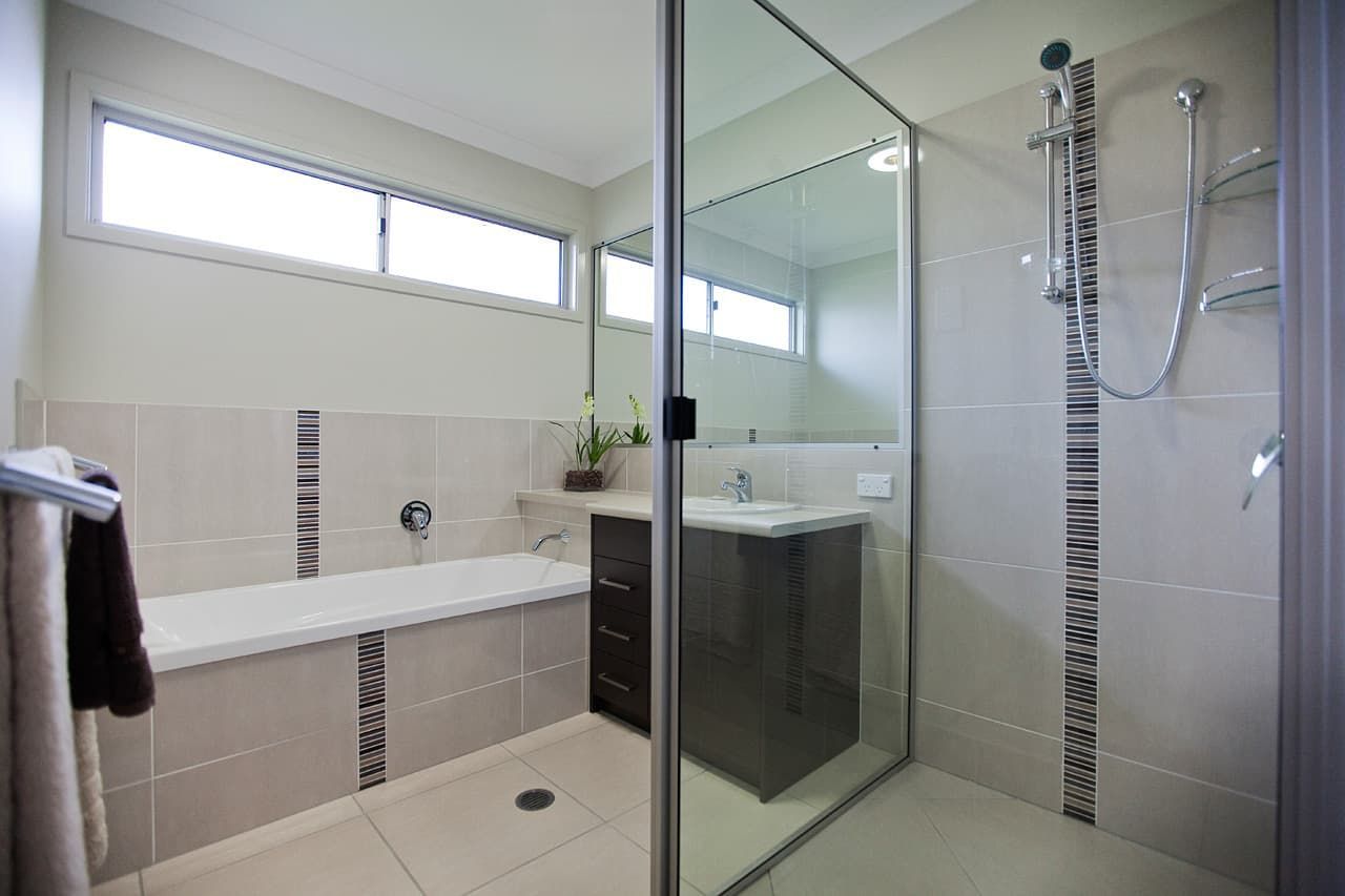 A Modern Bathroom Featuring a White Bathtub, a Dark Wooden Vanity — Craftsmen Kitchens In Monkland, QLD