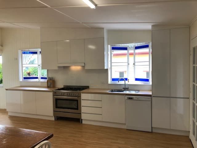 A Modern, Minimalist Kitchen Featuring Glossy White Cabinets — Craftsmen Kitchens In Monkland, QLD