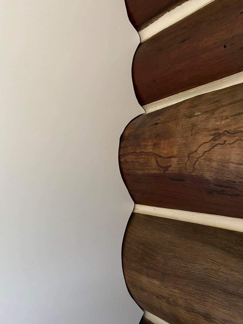 A Close-up View of Stacked Dark Brown Wooden Logs — Craftsmen Kitchens In Monkland, QLD